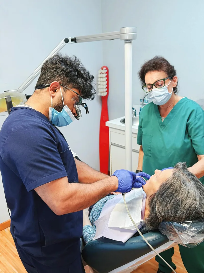 Dr. Hussain treating a patient with the help of a dental assistant